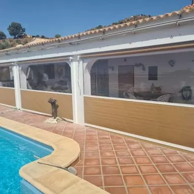 Cerramiento con toldos bajantes , con gu&iacute;as y ventana panor&aacute;mica