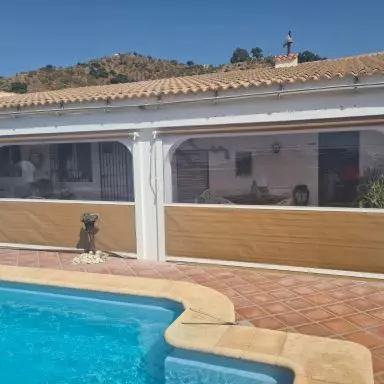 Cerramiento con toldos bajantes , con gu&iacute;as y ventana panor&aacute;mica